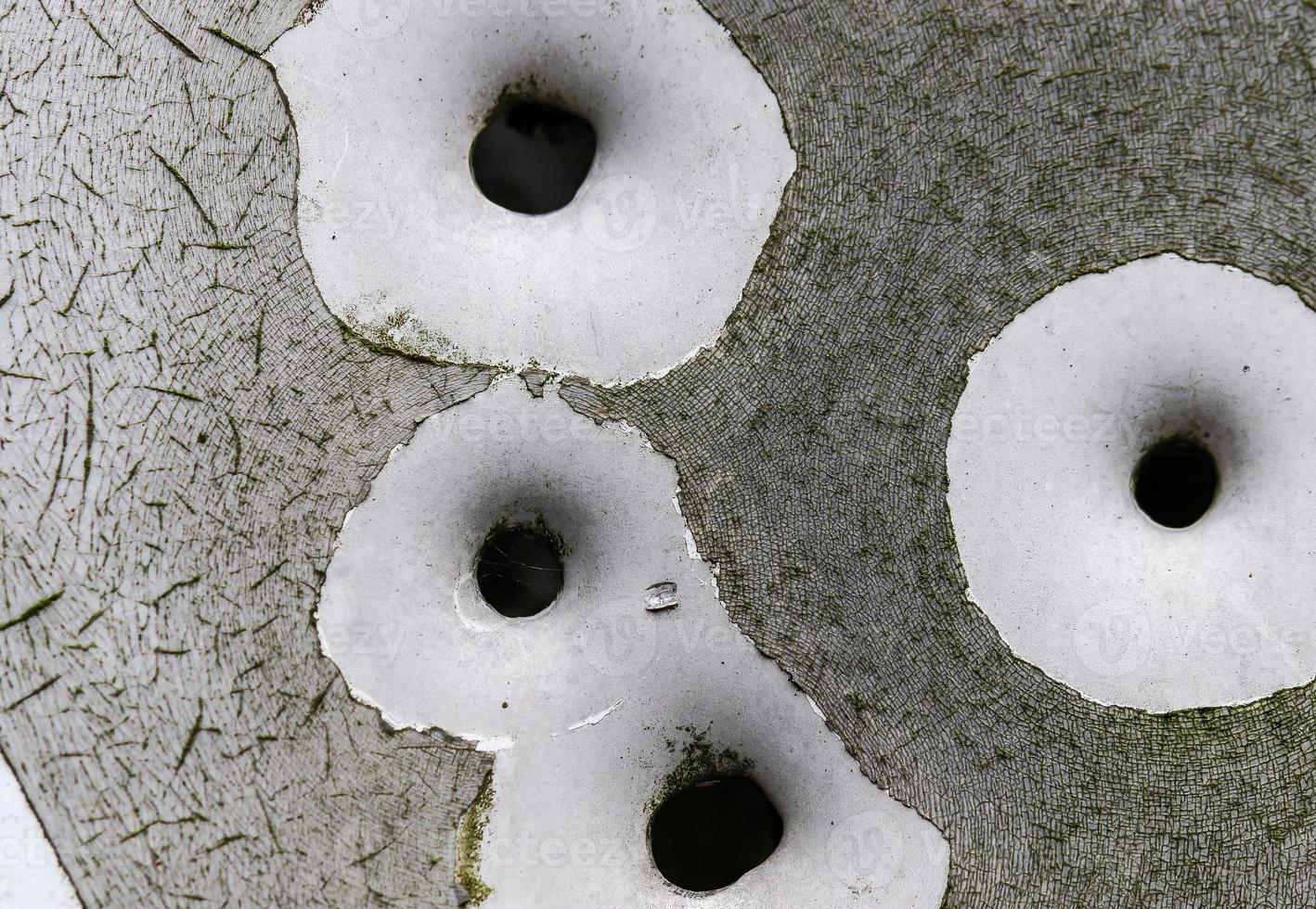 Detailed close up of bullet holes from gun shots in a traffic sign photo