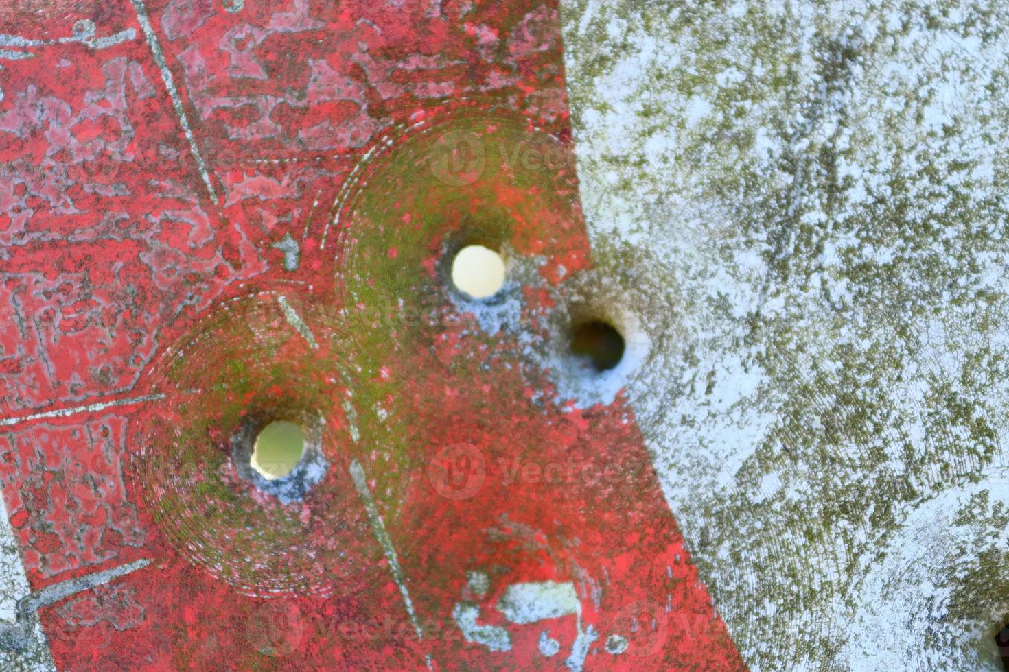 Detailed close up of bullet holes from gun shots in a traffic sign photo