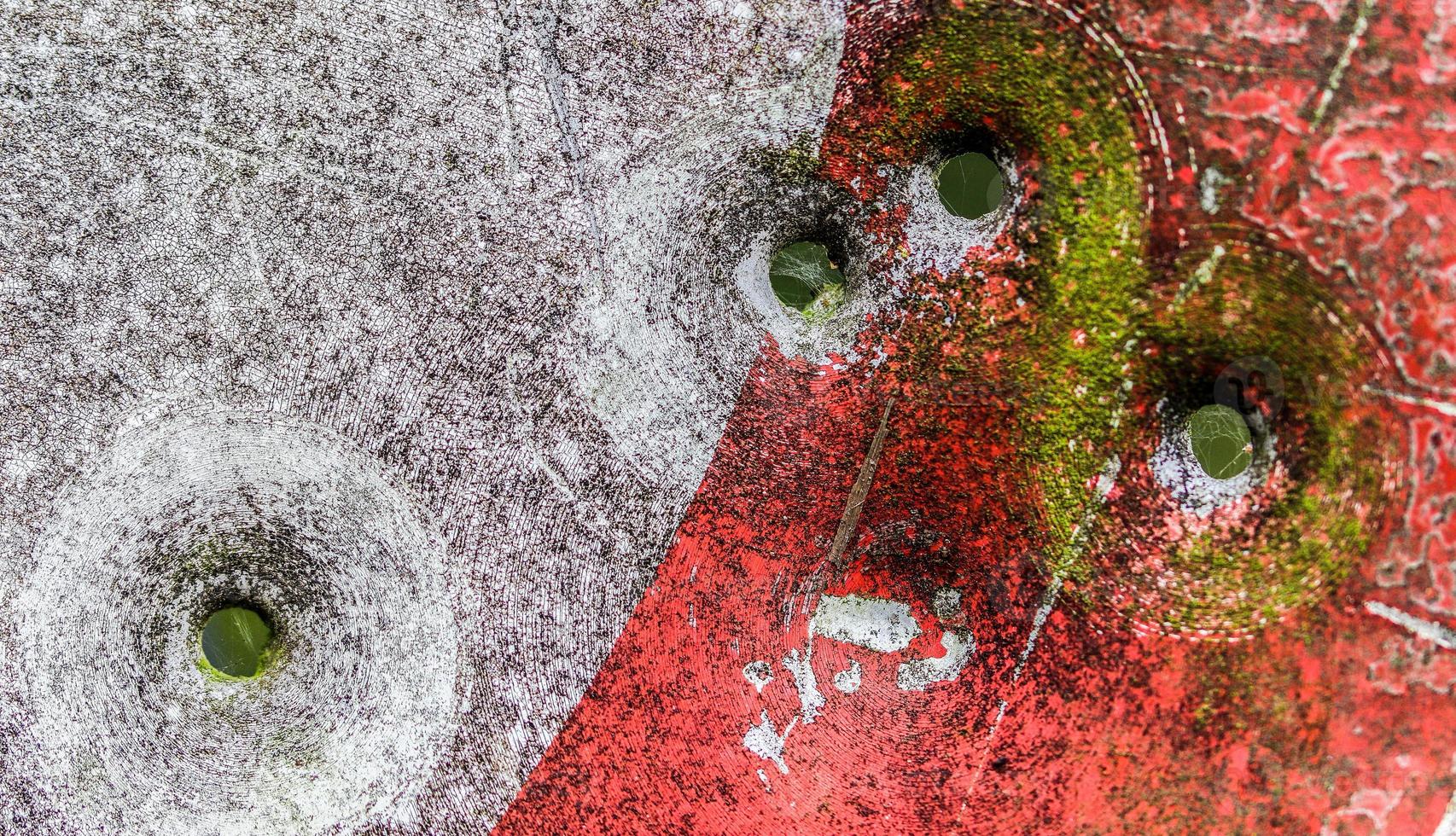 Detailed close up of bullet holes from gun shots in a traffic sign photo