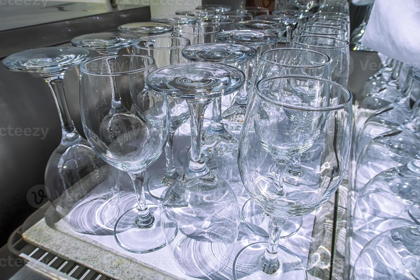 Rows of empty wine glasses close up. Glass goblets on the table. Restaurant bar concept photo