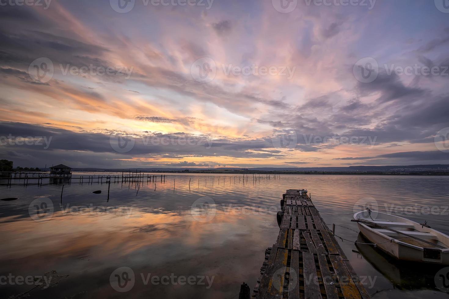 mood and tranquility at a lake coast with a boat at a wooden pier photo
