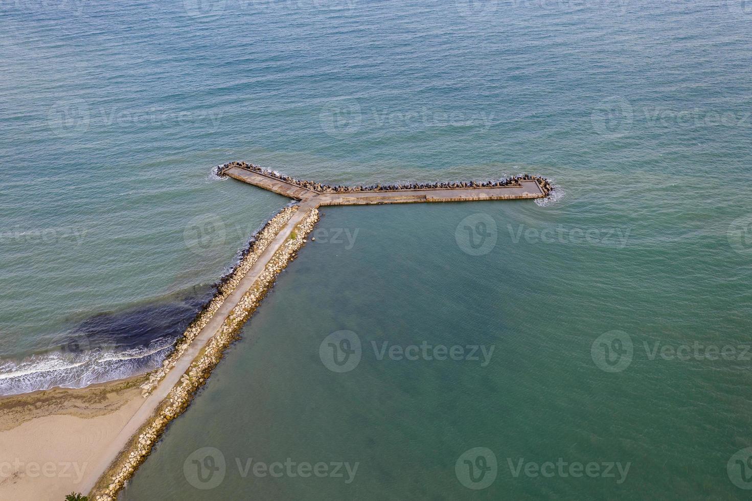 Aerial view from drone of the sea, beach and wave breaker stones photo