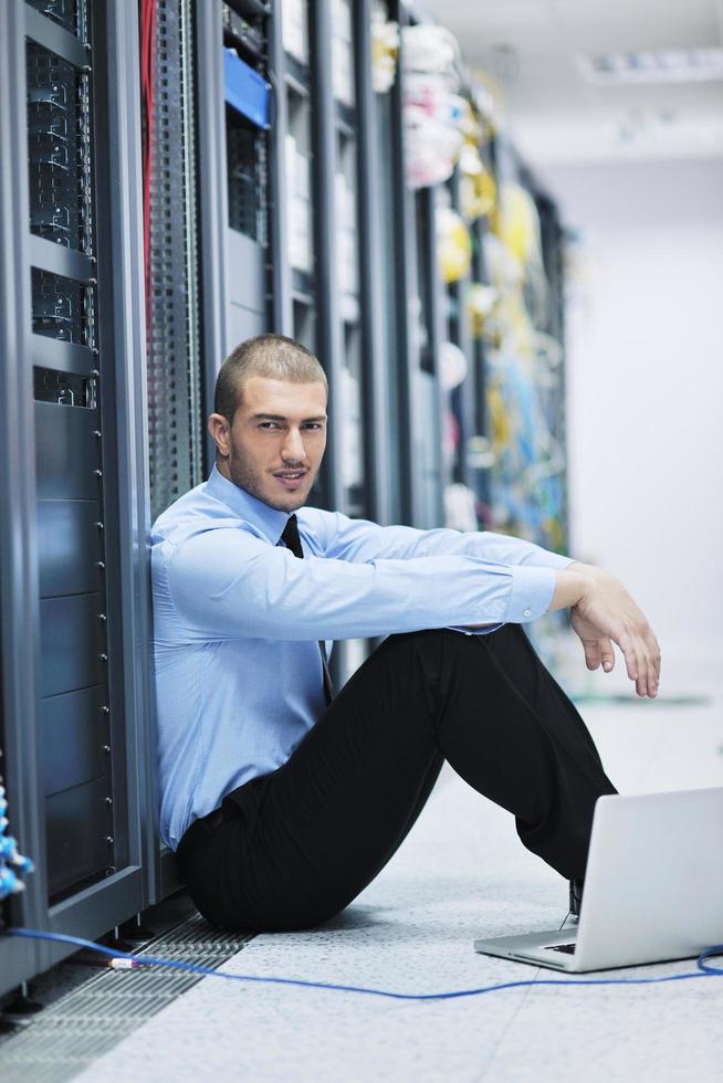 businessman with laptop in network server room photo