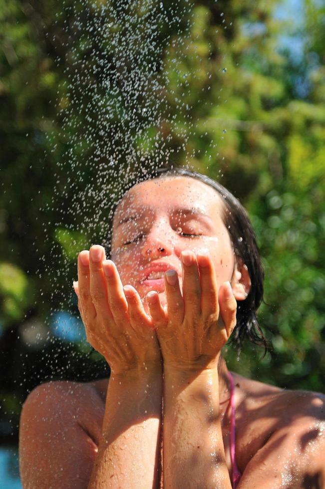 mujer bonita joven que se relaja bajo la ducha foto