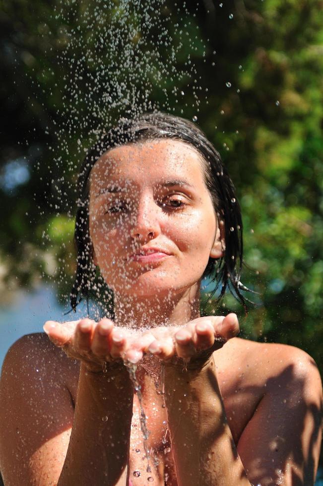 mujer bonita joven que se relaja bajo la ducha foto