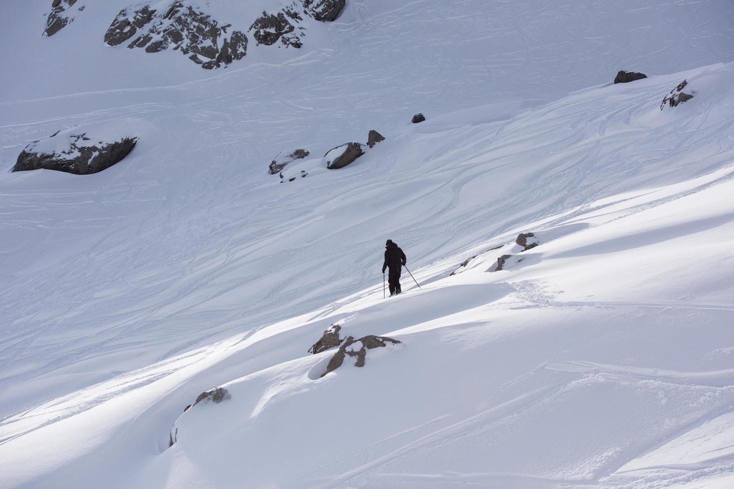 esquiador de freeride esquiando en nieve polvo profunda foto