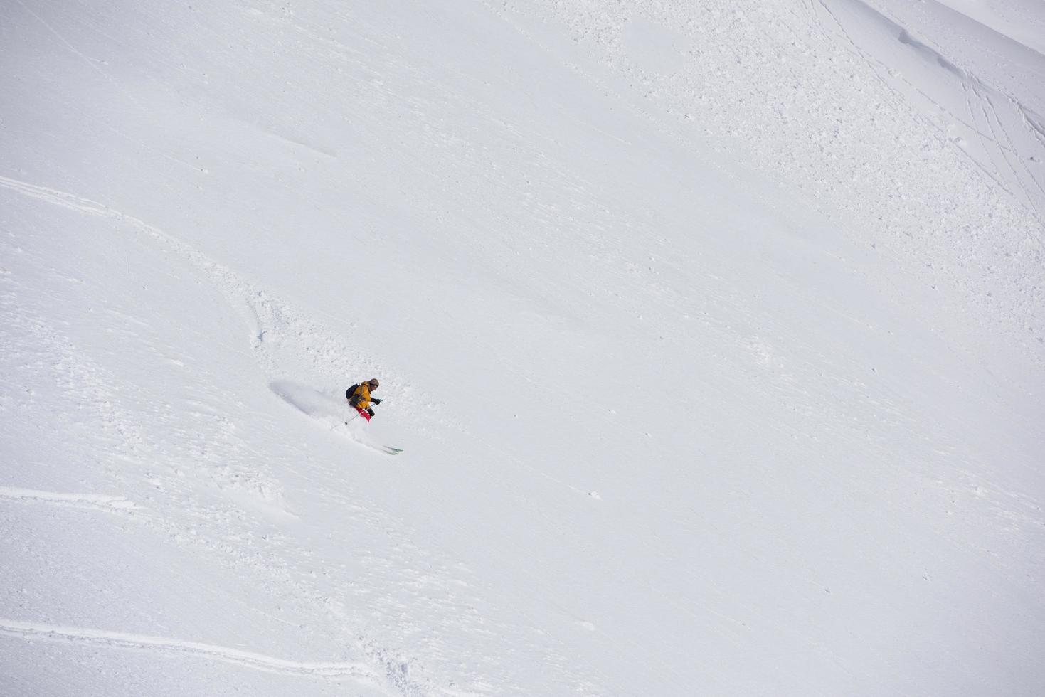 freeride skier skiing in deep powder snow photo
