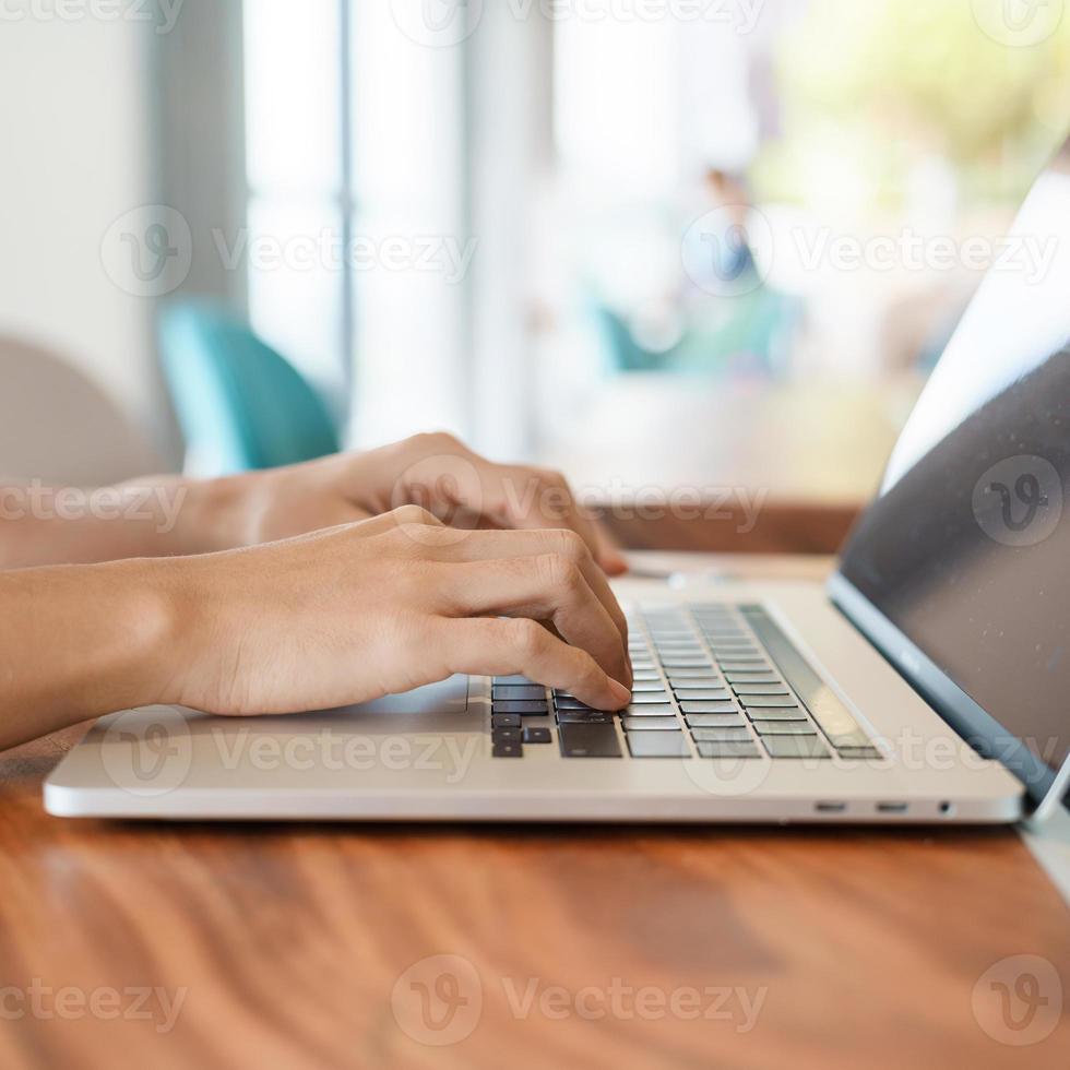 woman using laptop, freelance woman typing keyboard computer notebook in cafe or modern office. technology, digital online and network concept photo