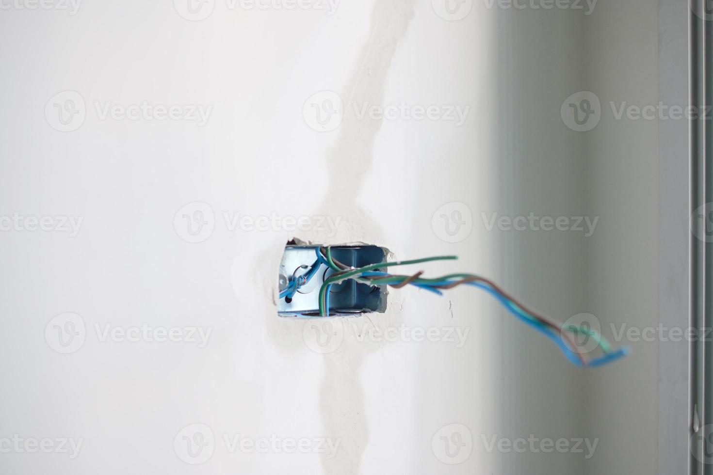 Electrical Wiring under plaster, hidden installation cables for socket to a concrete. Renovation, Repair and development of home and apartment concepts photo