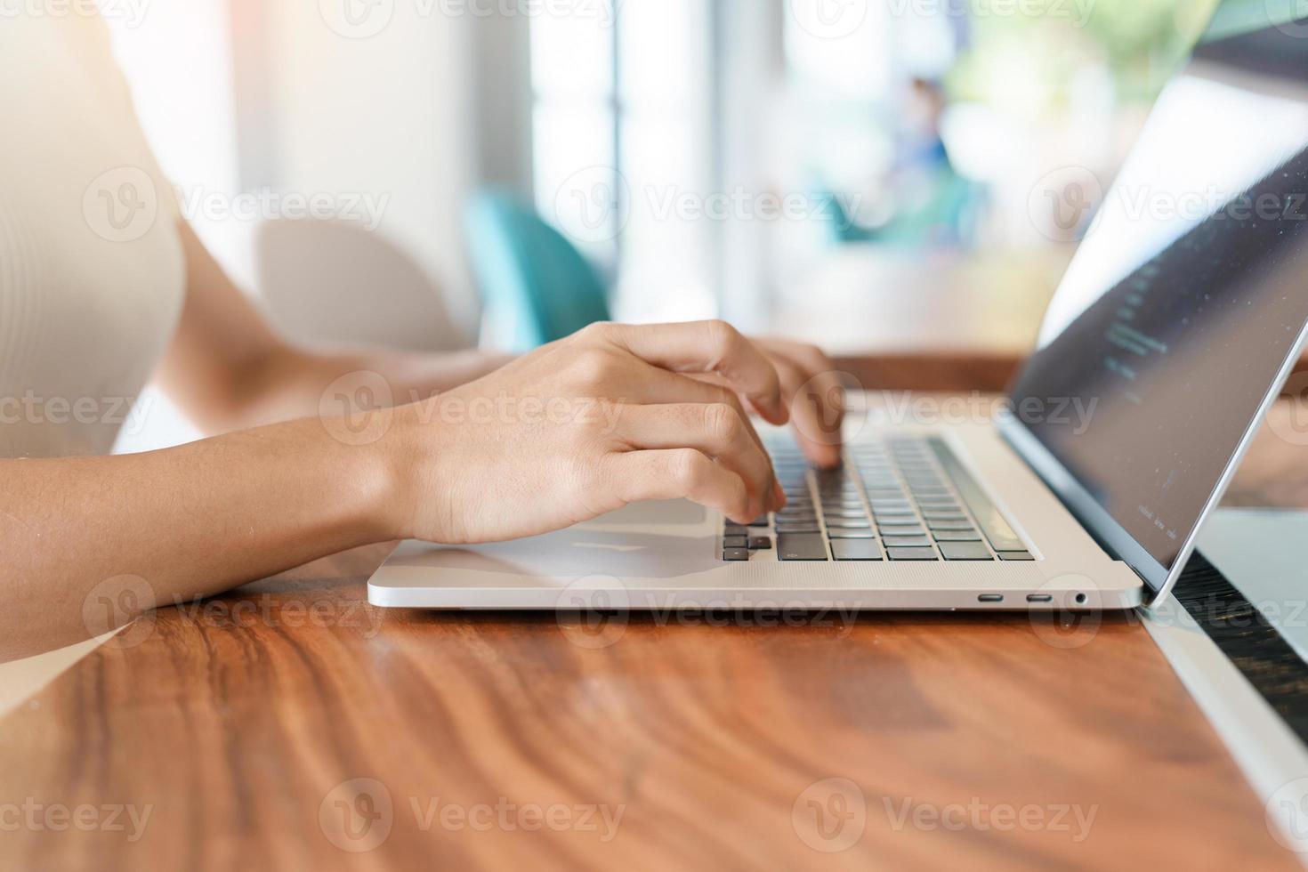 woman using laptop, freelance woman typing keyboard computer notebook in cafe or modern office. technology, digital online and network concept photo