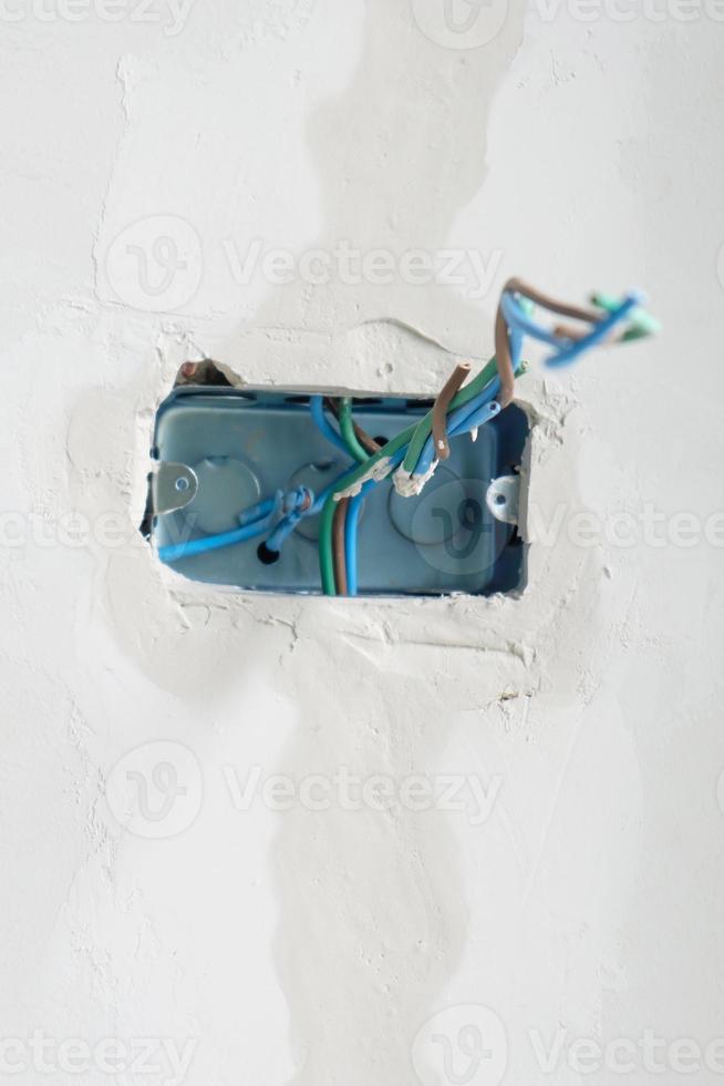 Electrical Wiring under plaster, hidden installation cables for socket to a concrete. Renovation, Repair and development of home and apartment concepts photo