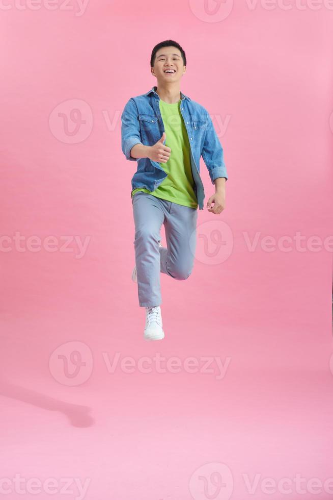 hombre guapo saltando sobre rosa foto