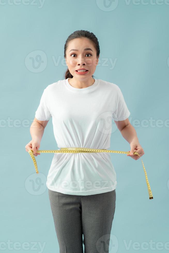 astonished slim woman measuring her waist photo