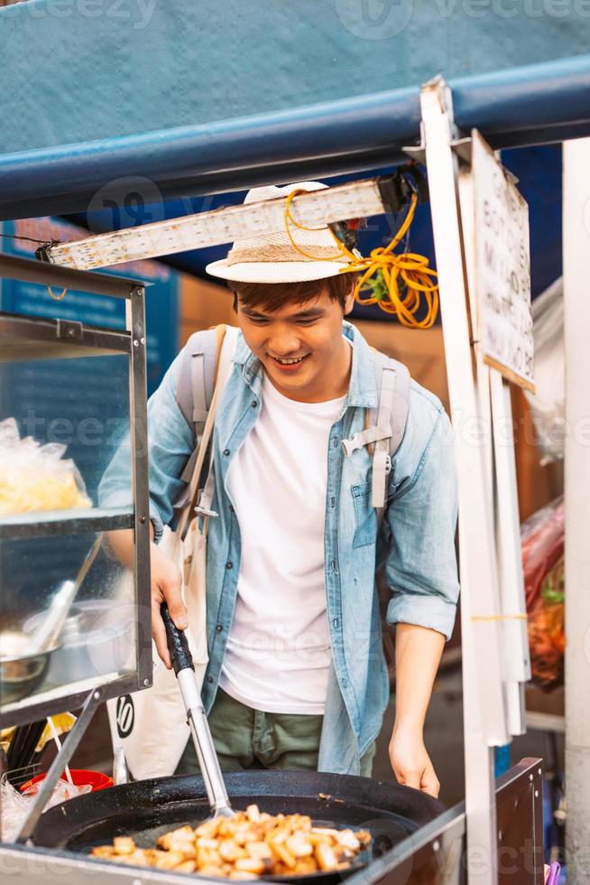 Happy girl traveler buying street food on food market photo