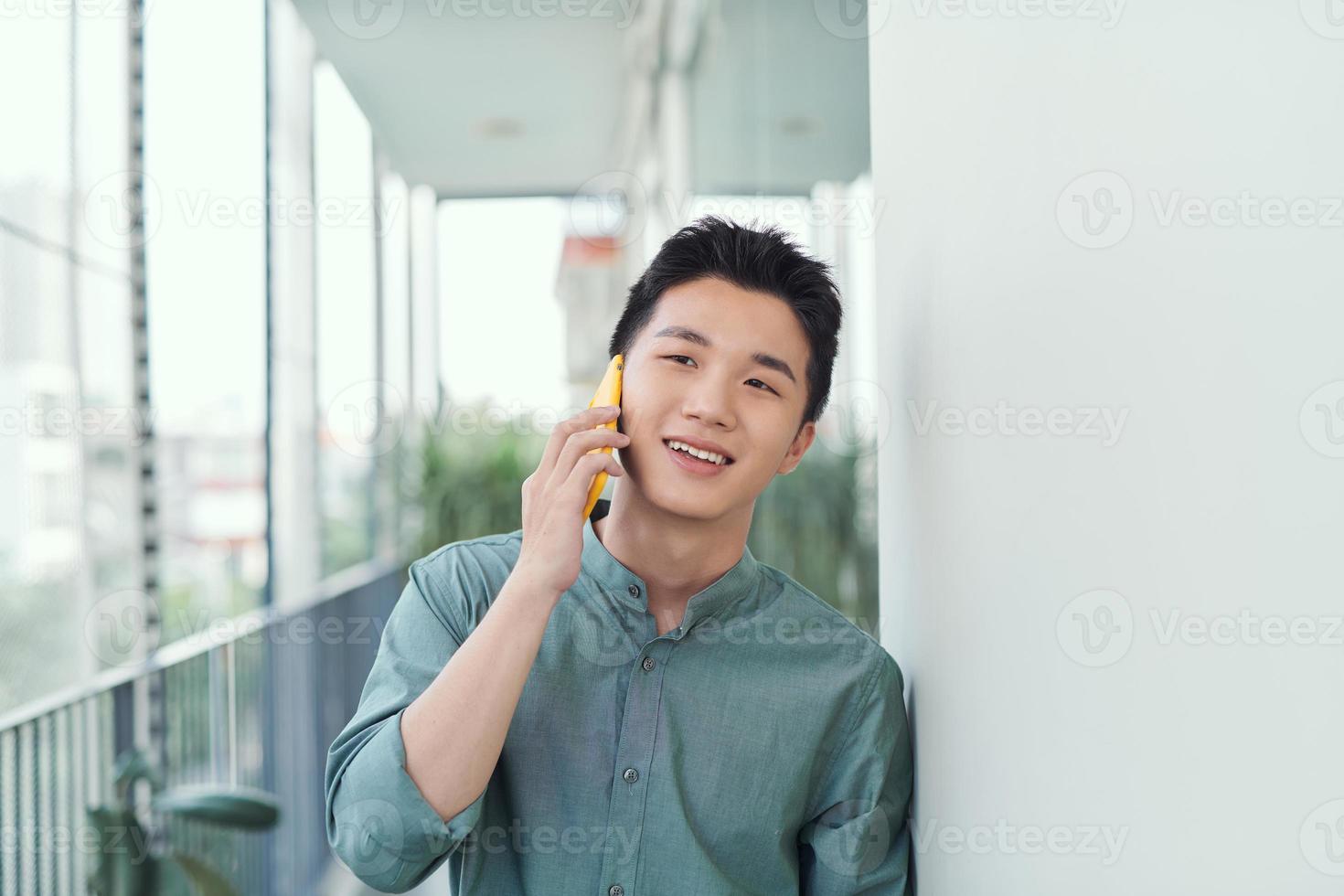 A portrait of man standing at a balcony making a phone call. photo