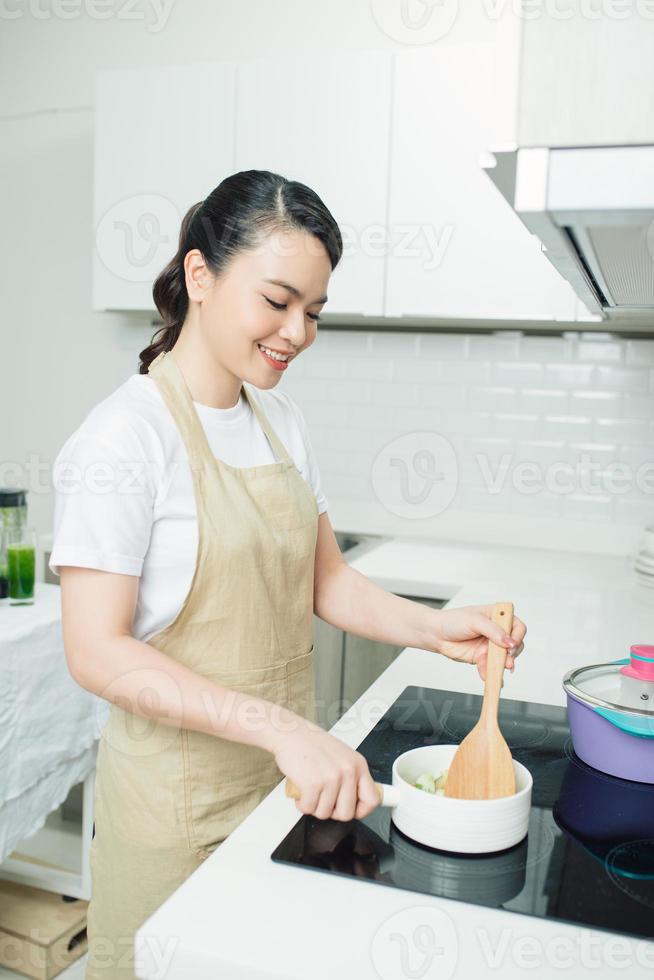 mujer joven cocinando en la cocina foto