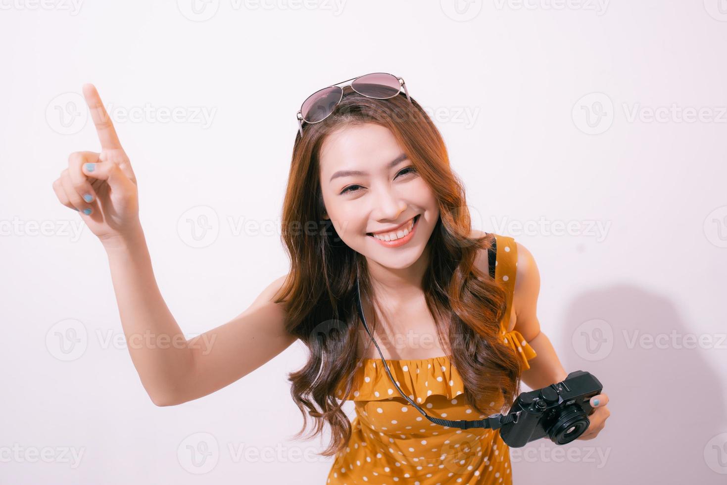 Stylish smiling woman posing with retro camera on pink background. photo