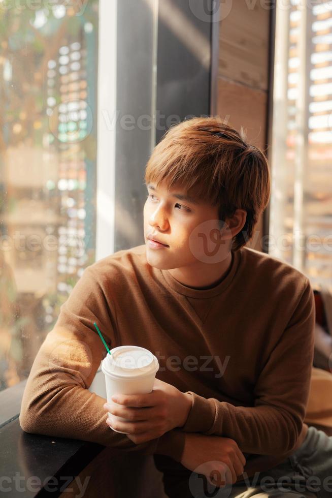 joven bebiendo café en una cafetería. foto