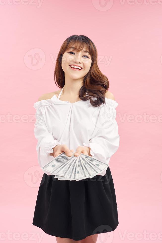 Photo of rich woman in basic clothing holding fan of dollar money isolated over pink background