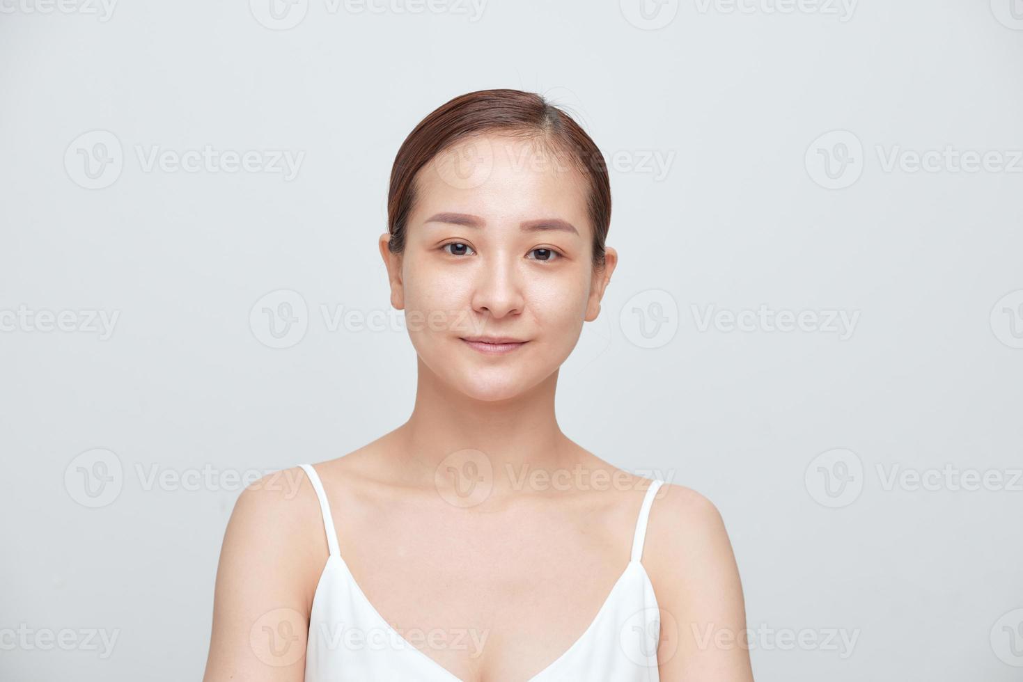 Portrait of young woman with no make up over white background photo