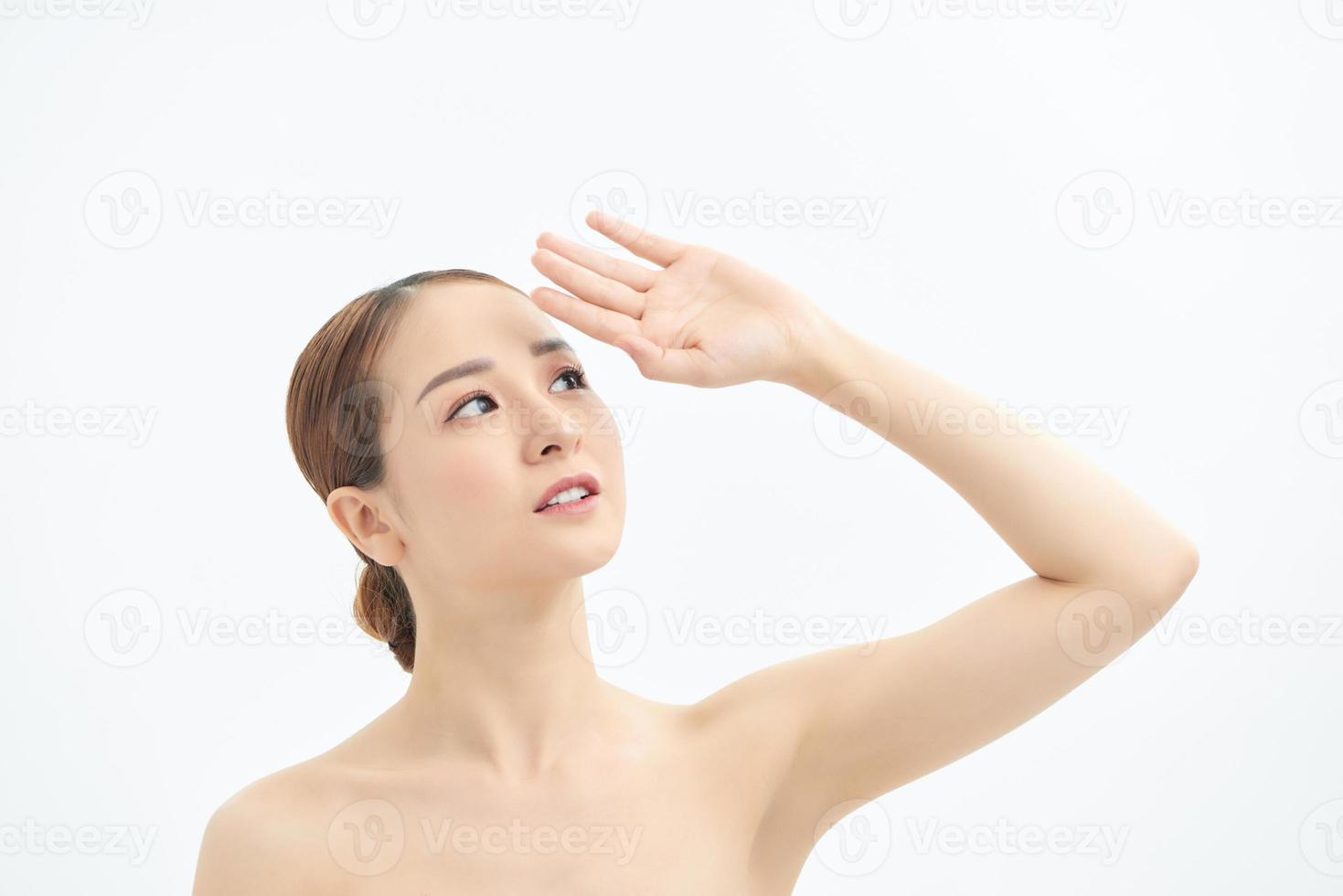 Close up of young naked Asian woman looking up and showing hand. Isolated on white background. photo