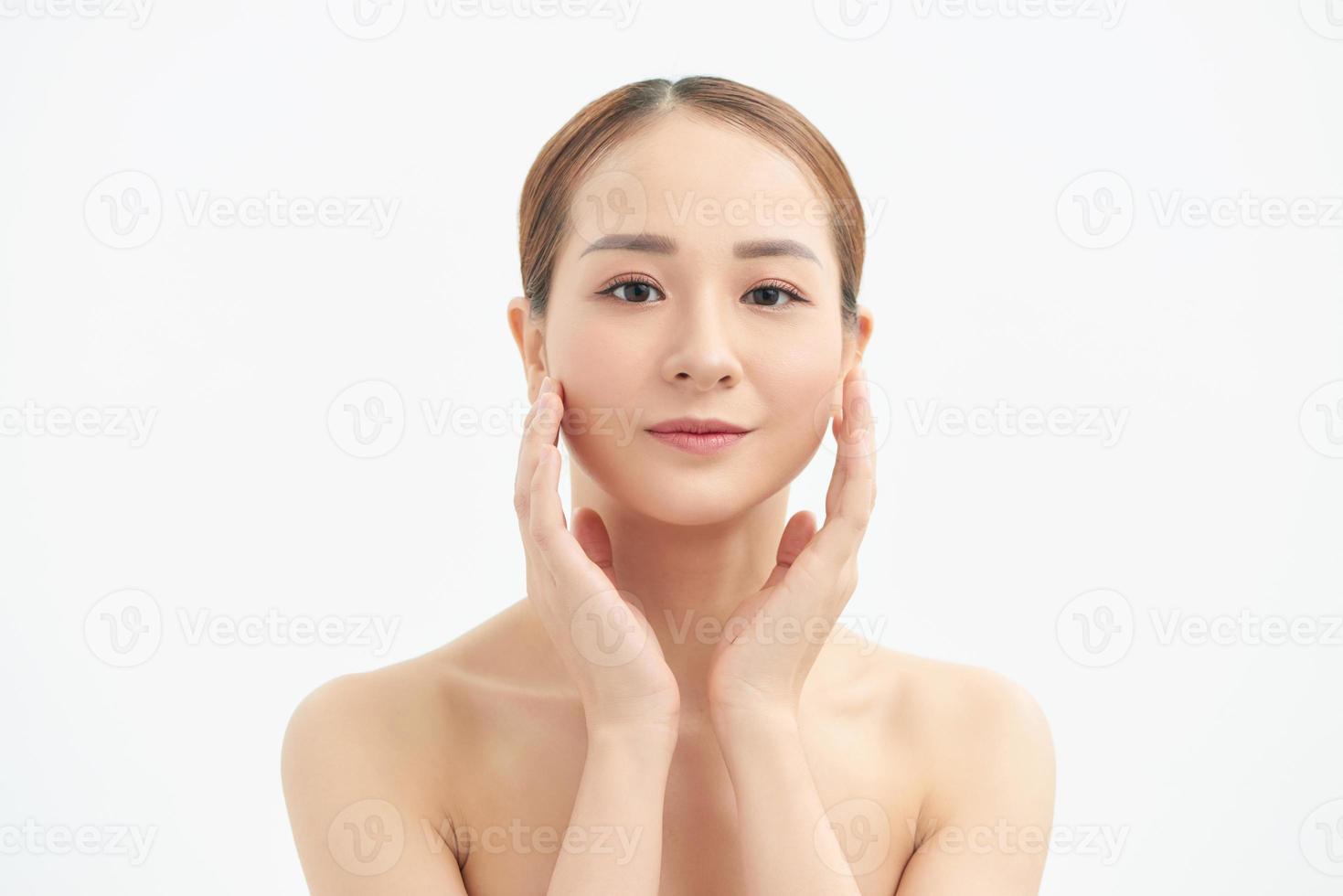 Portrait of young beautiful Asian woman touching her face with naked body over white background. photo