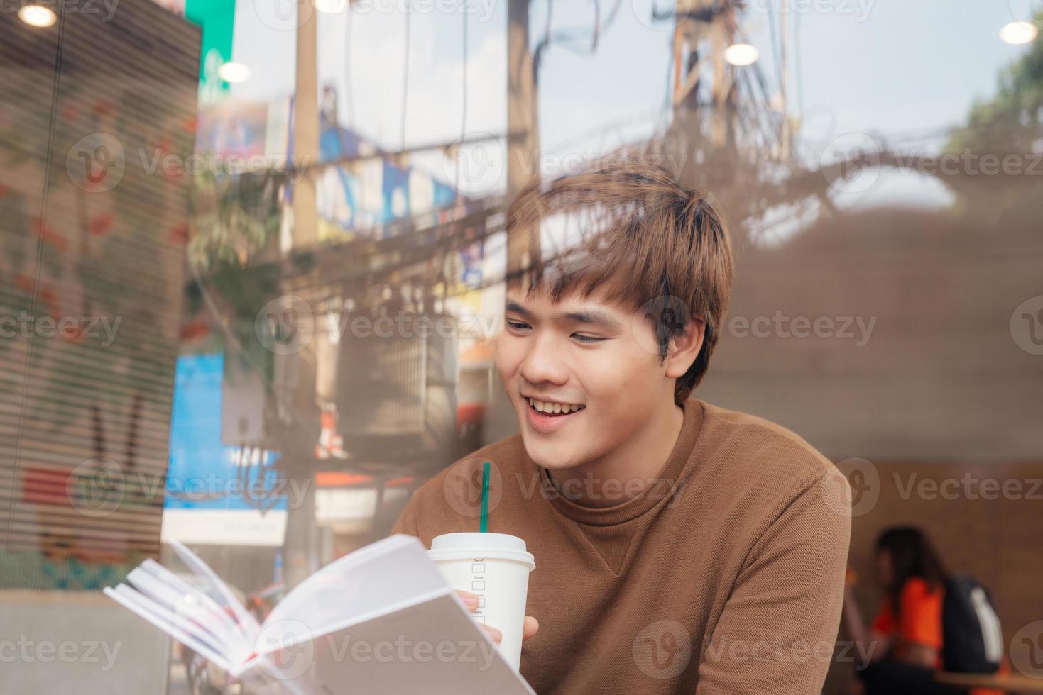 Handsome man sitting alone at table in coffee shop cafe working photo