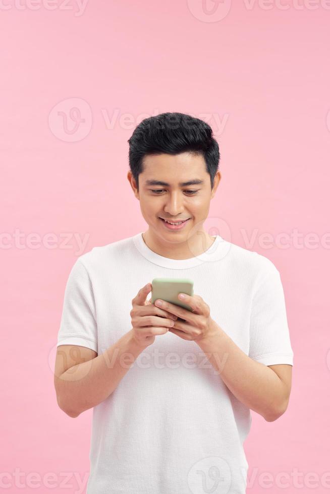 Portrait of young happy Asian man using phone photo