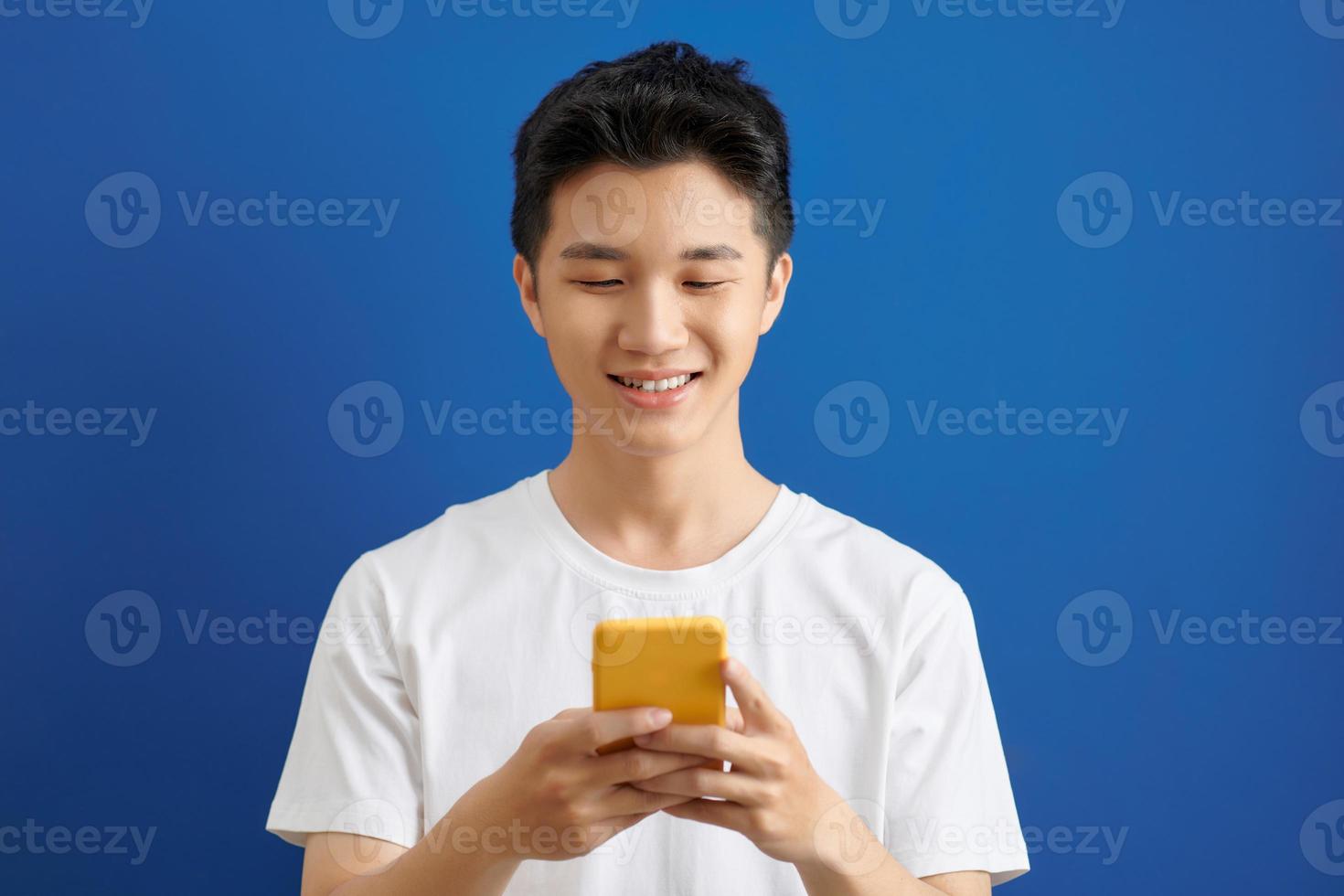 handsome young man sending text messages with is mobile phone, photo