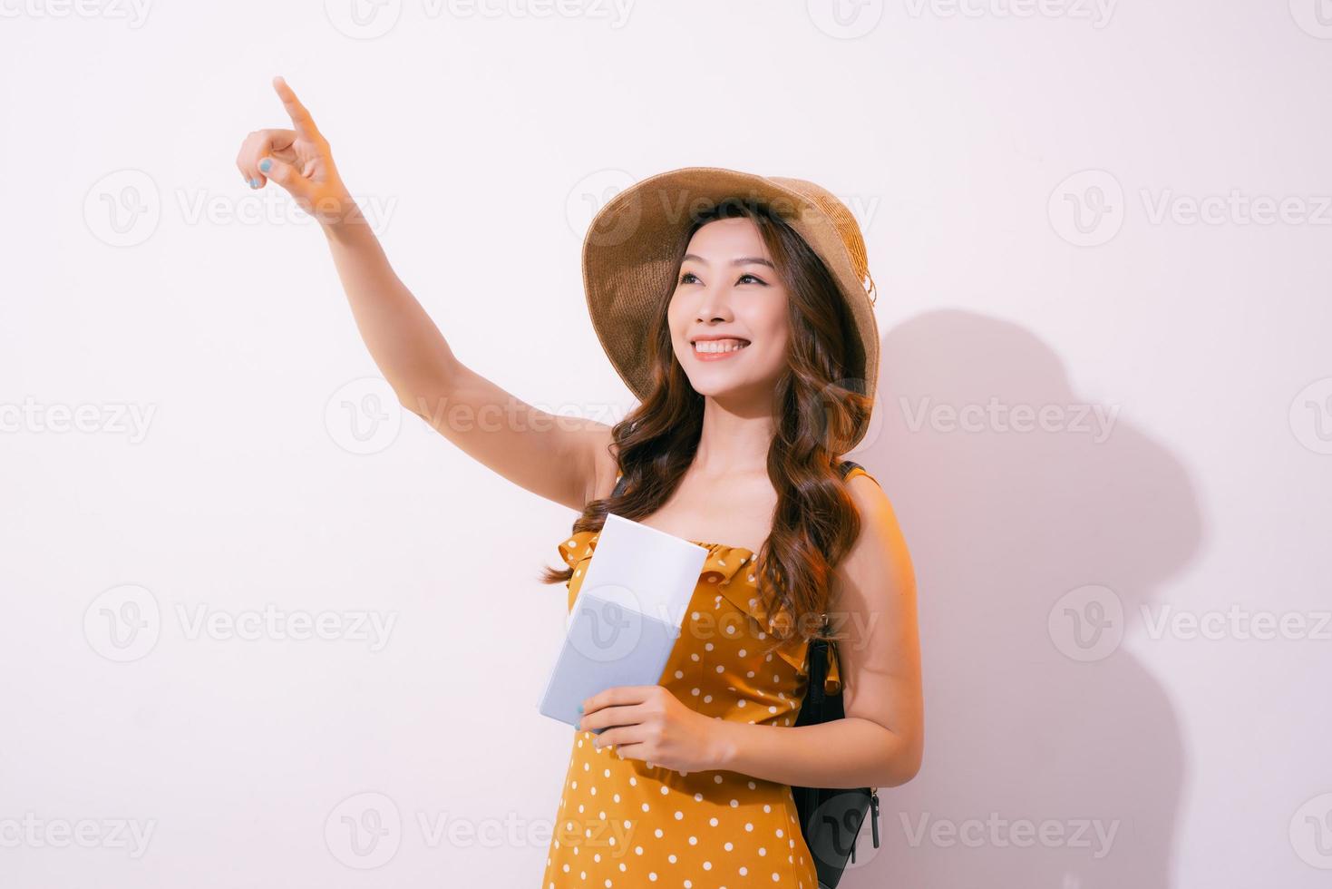 Portrait of a happy smiling young girl holding passport and travelling tickets isolated over pastel background photo