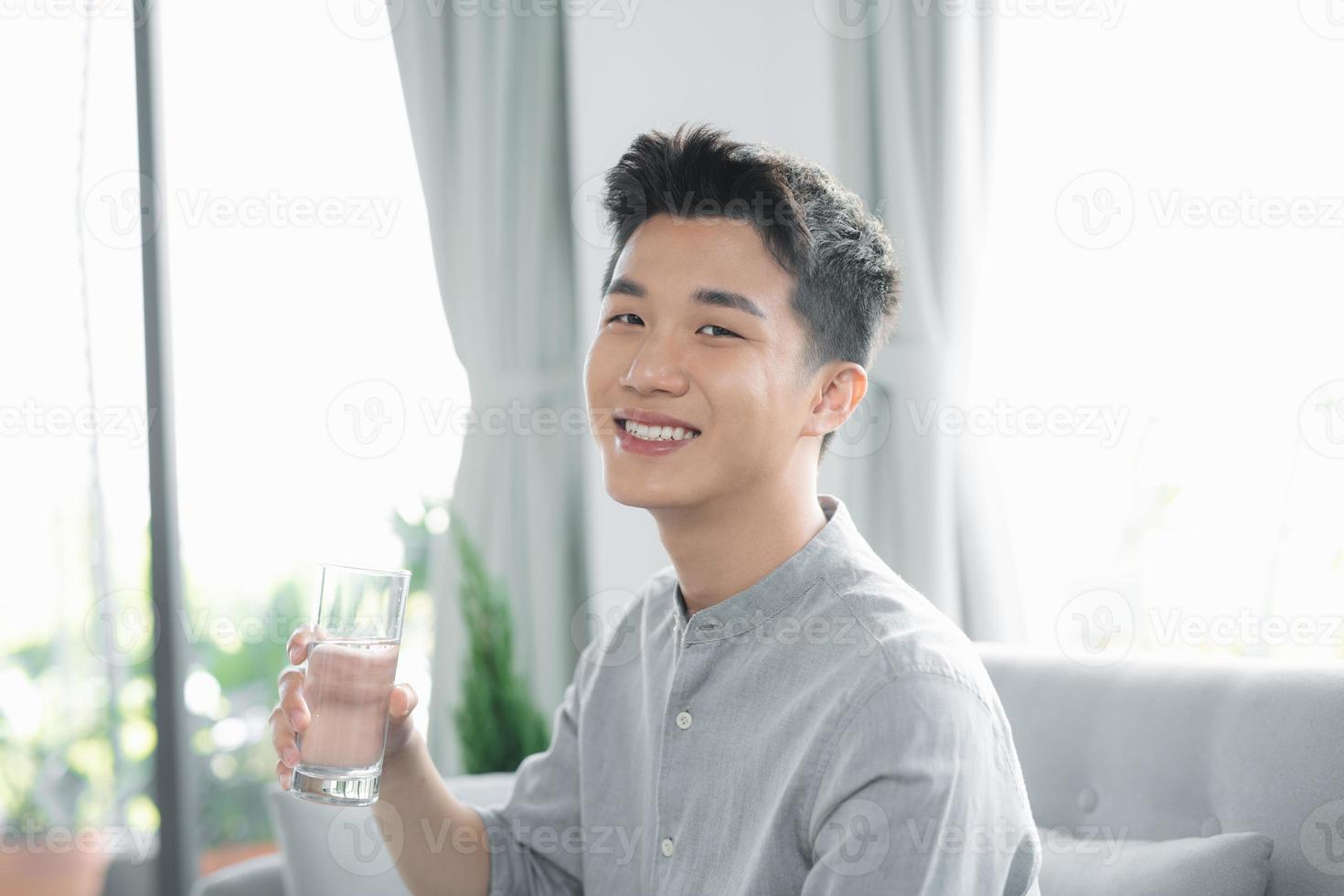 Handsome man drinking a fresh glass of water photo