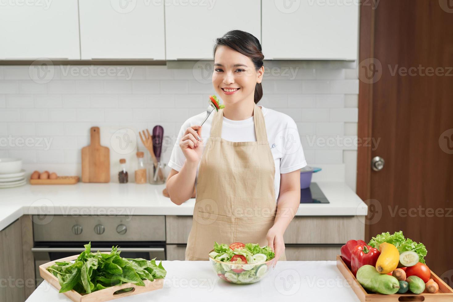 Vertical photo of a young woman who eats salad at home, a concept diet