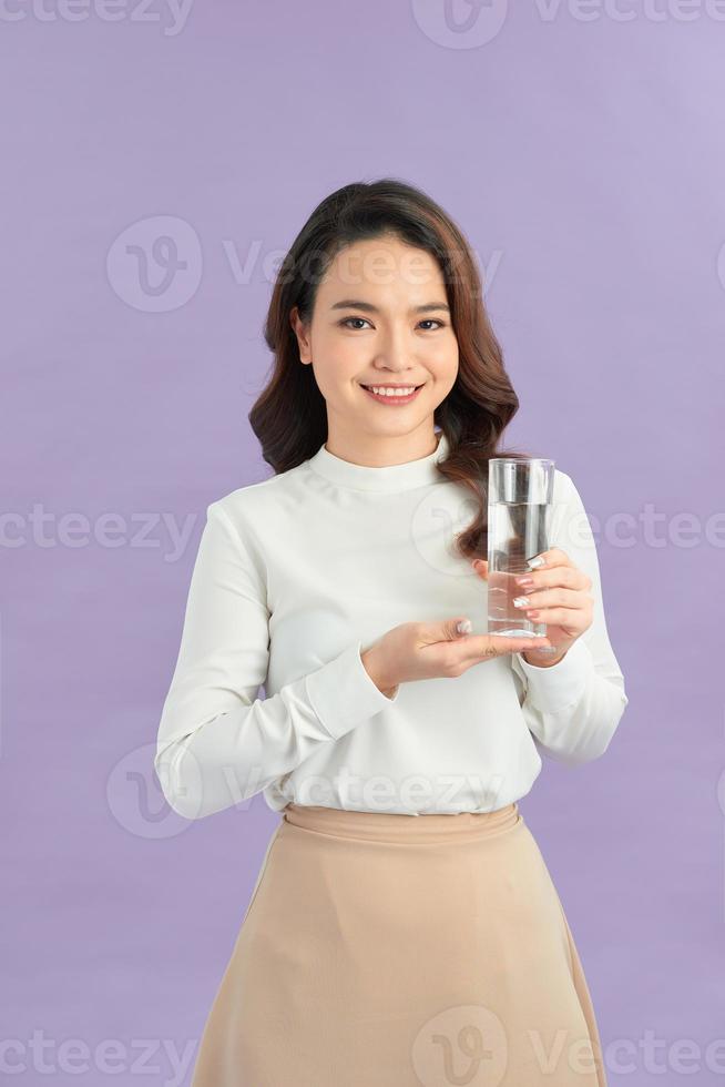 Young smiling woman holding water glass. photo