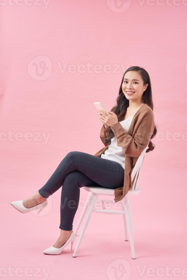 attractive model using digital device, casual outfit, positive face expression, isolated photo