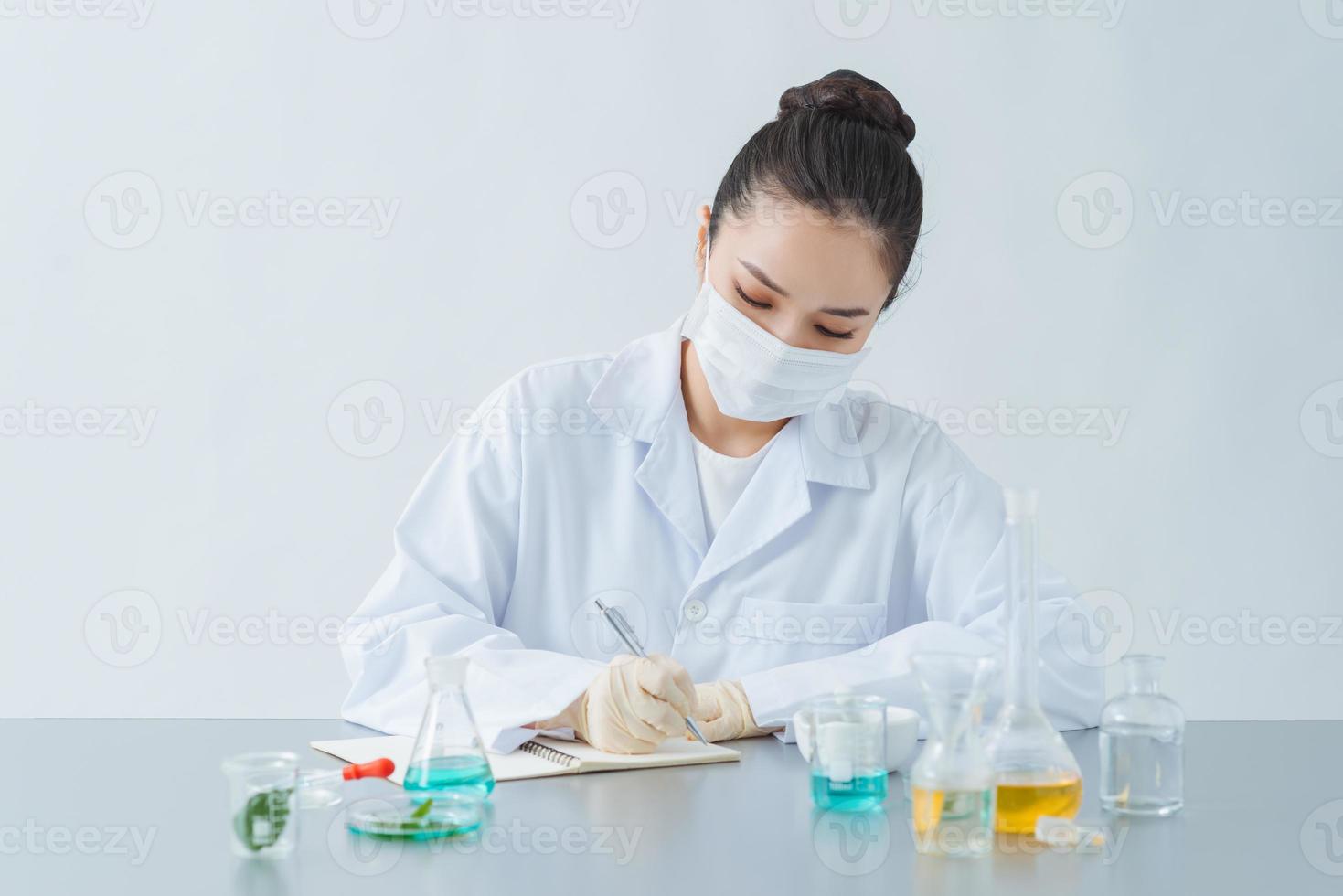 dermatólogo femenino investigando para un nuevo producto para el cuidado de la piel en la mesa, cerrado foto