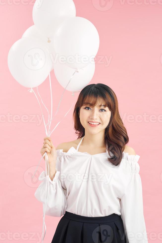 Beauty girl with white air balloons laughing, isolated on pink background photo