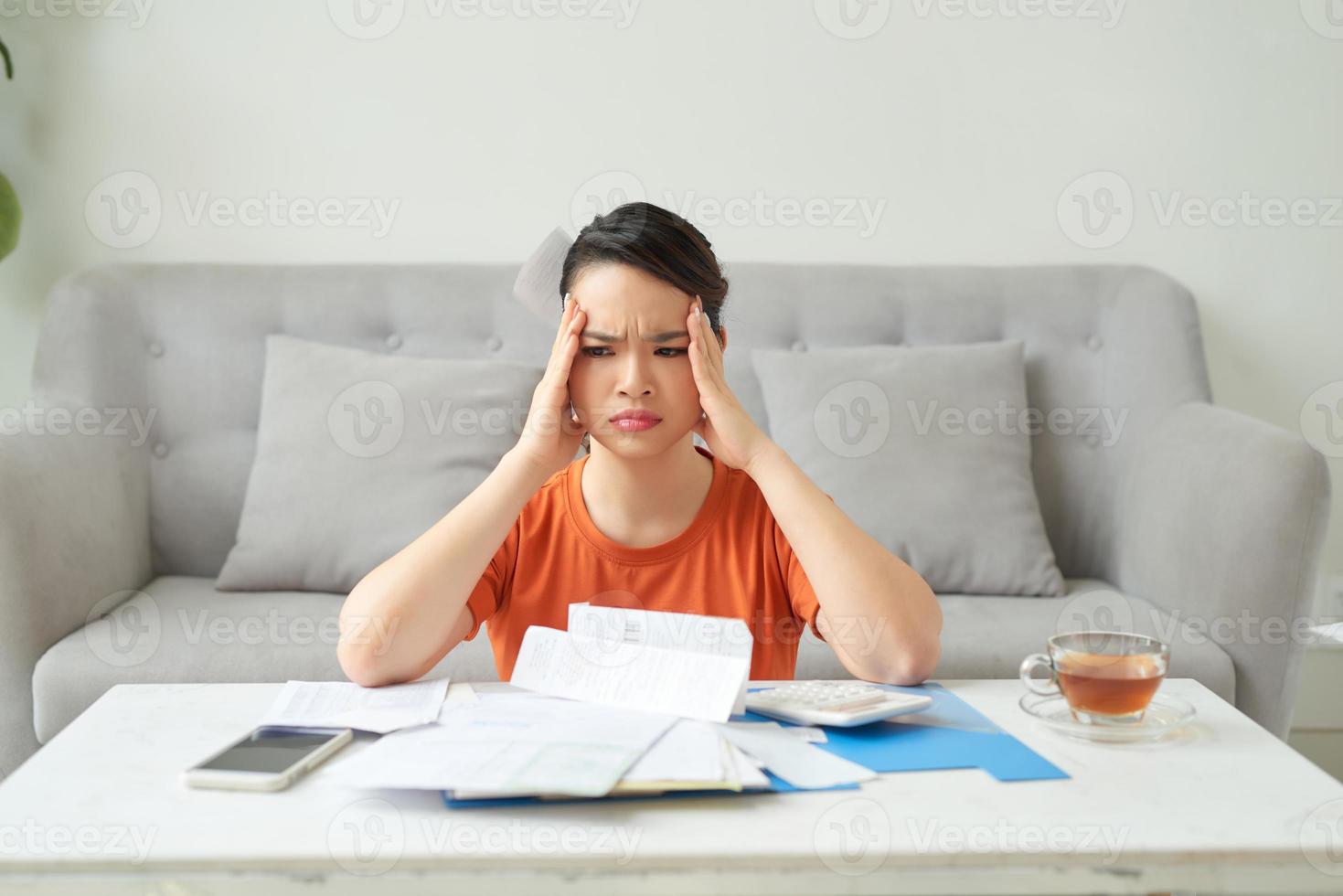 stressed Asian woman hand holding unpaid financial bills photo