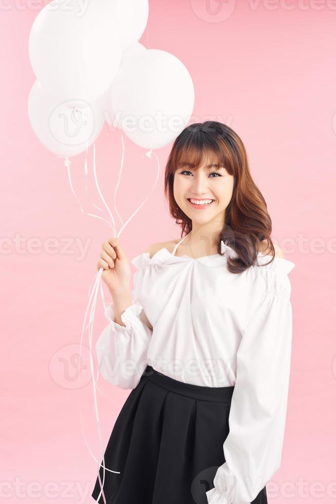 Beautiful young woman with balloons on a light background photo