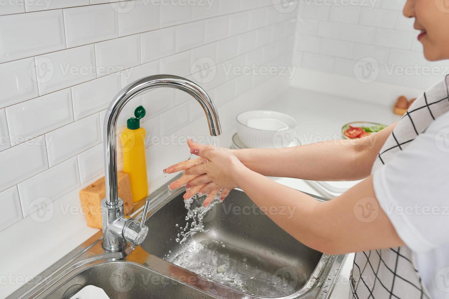 Woman Washing Hands In Kitchen Sink photo