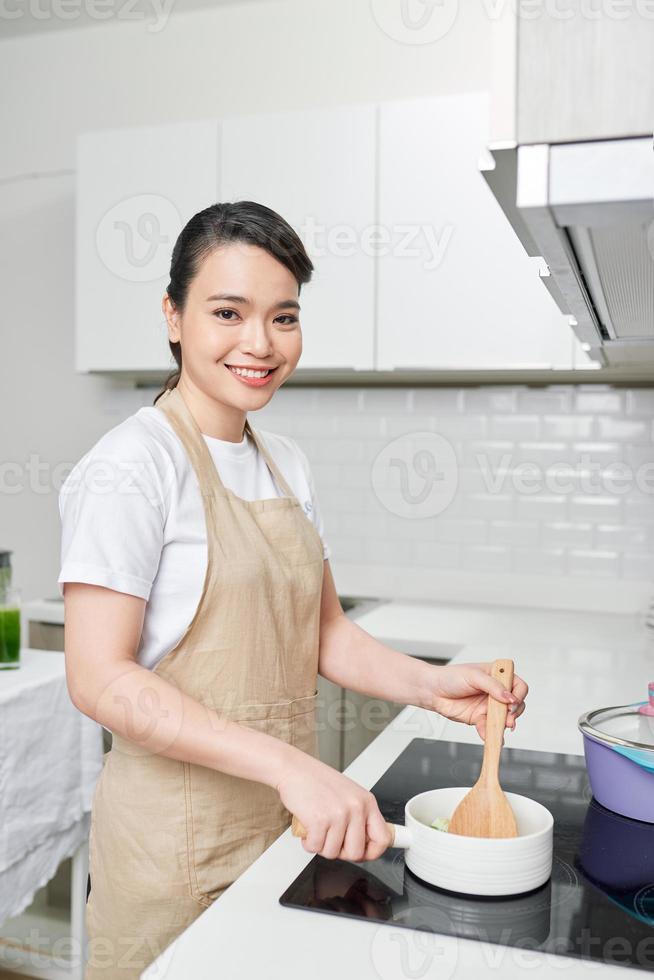 Young woman cooking in the kitchen photo