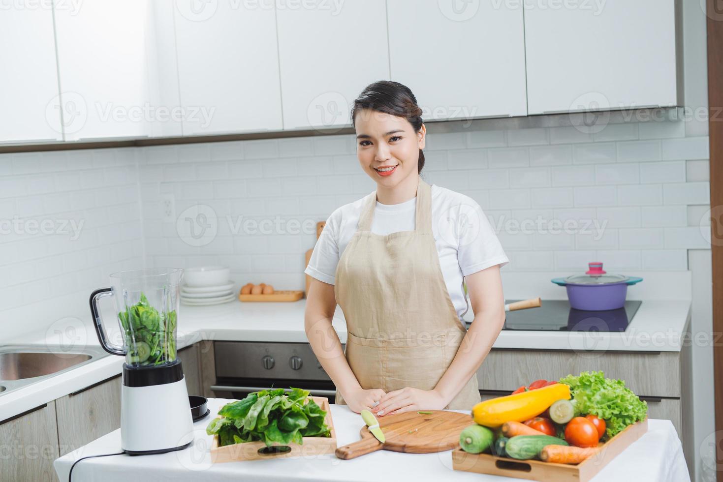 Woman cooking healthy detox smoothie with fresh fruits and green spinach, salad leaves. Lifestyle detox concept photo