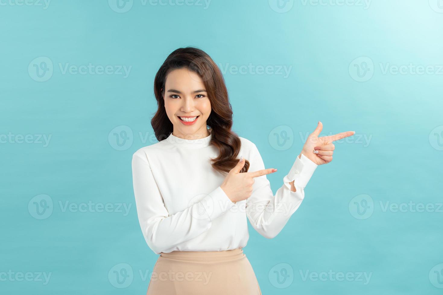 Friendly-looking female student showing you way, pointing fingers up at promo banner, photo