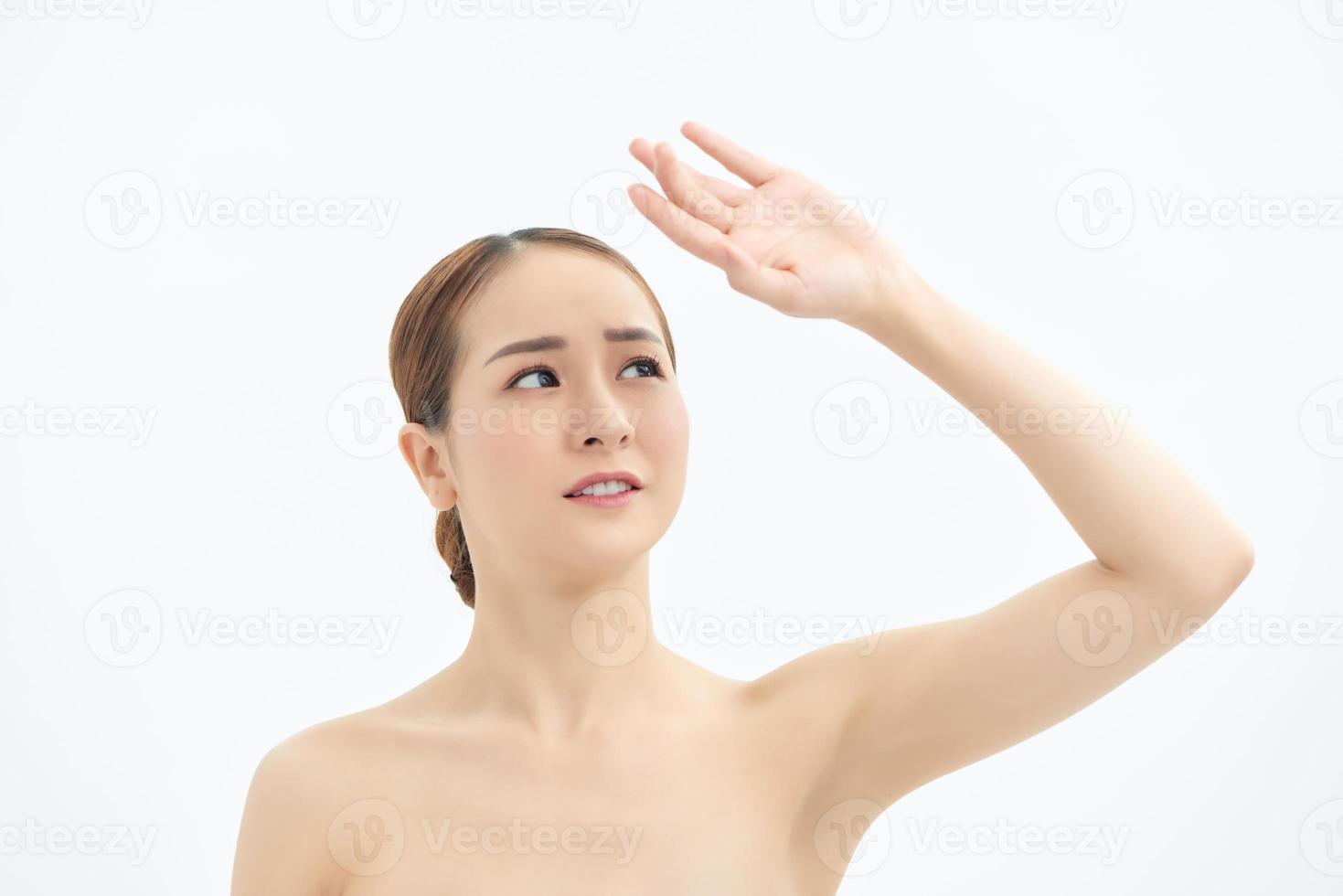 Young Asian woman looking up and showing hand to cover the light. photo