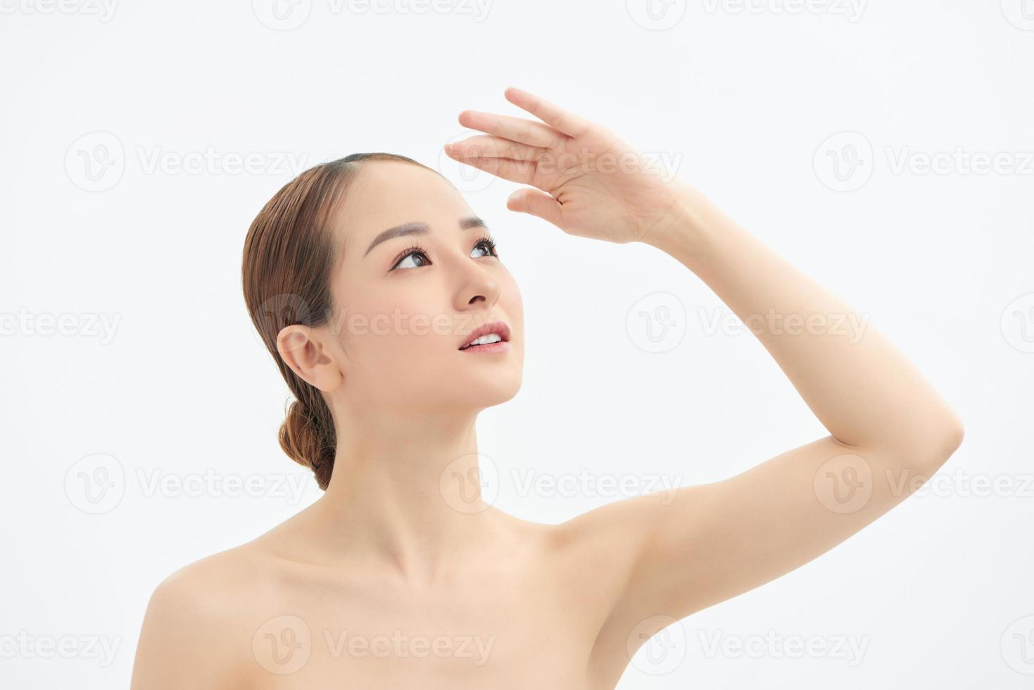 Young Asian woman looking up and showing hand to cover the light. photo