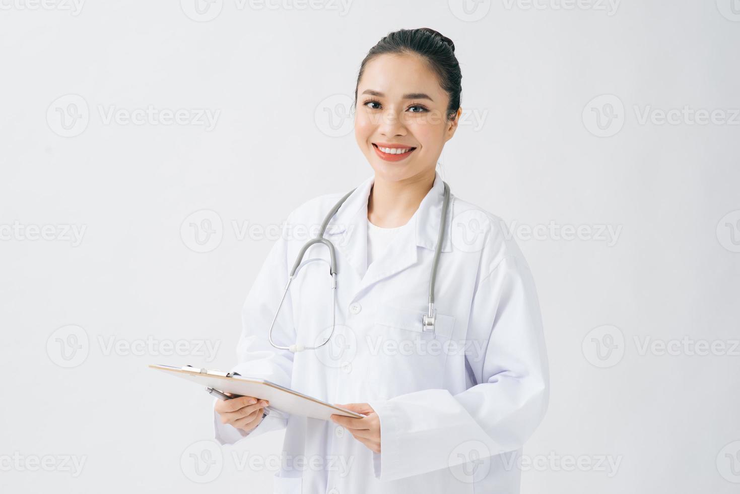 feliz joven doctora sosteniendo portapapeles con documentos sobre fondo blanco foto