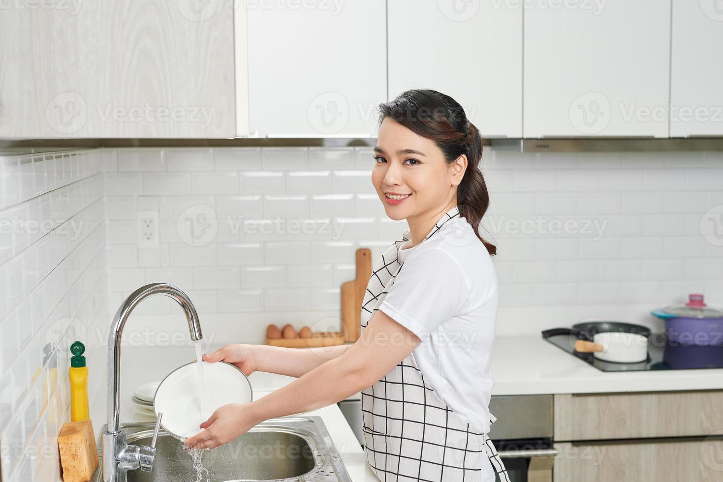 Asian lady wash a dish in kitchen room photo