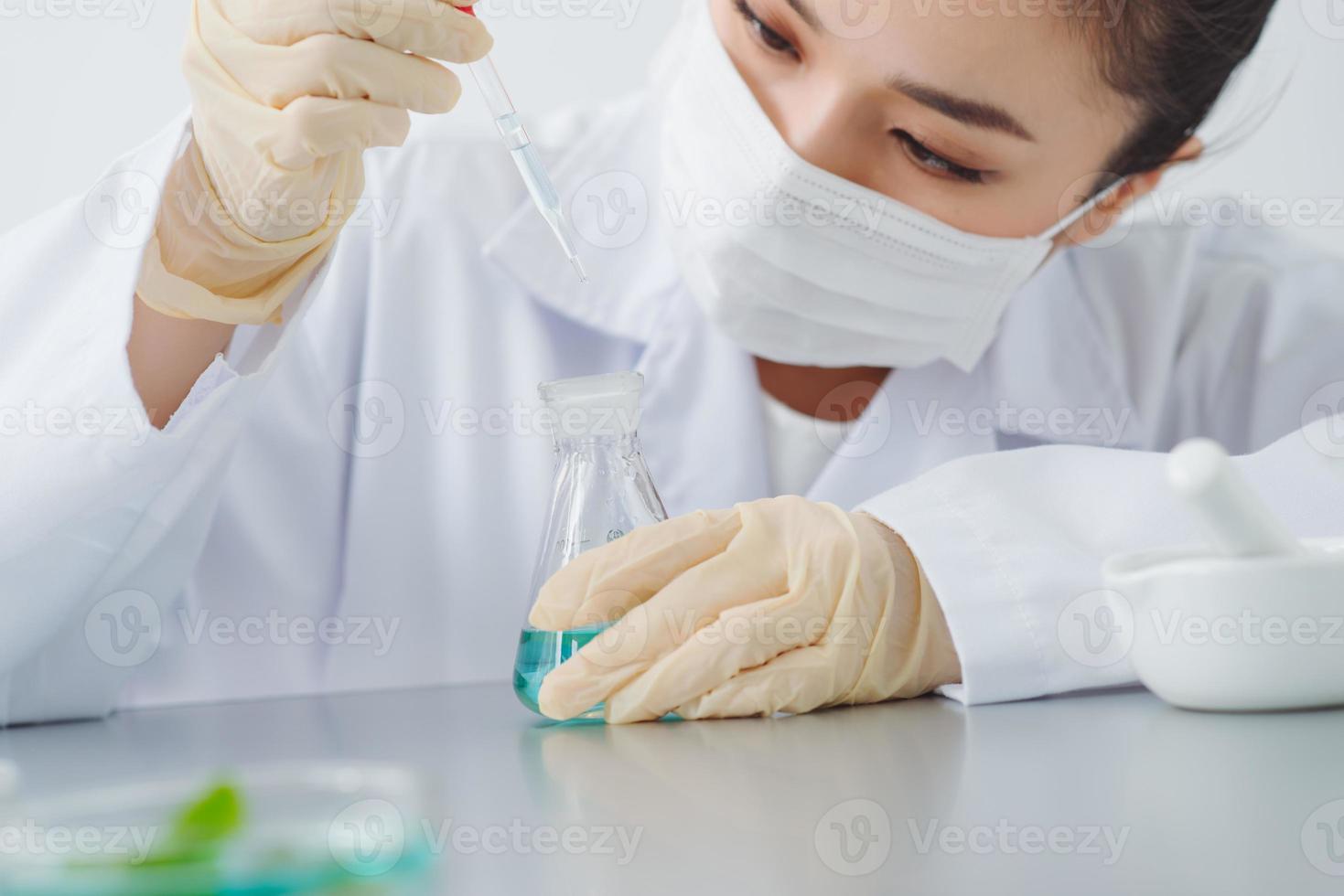 Lab worker dripping water into flask with leaf on blurred background, closeup photo