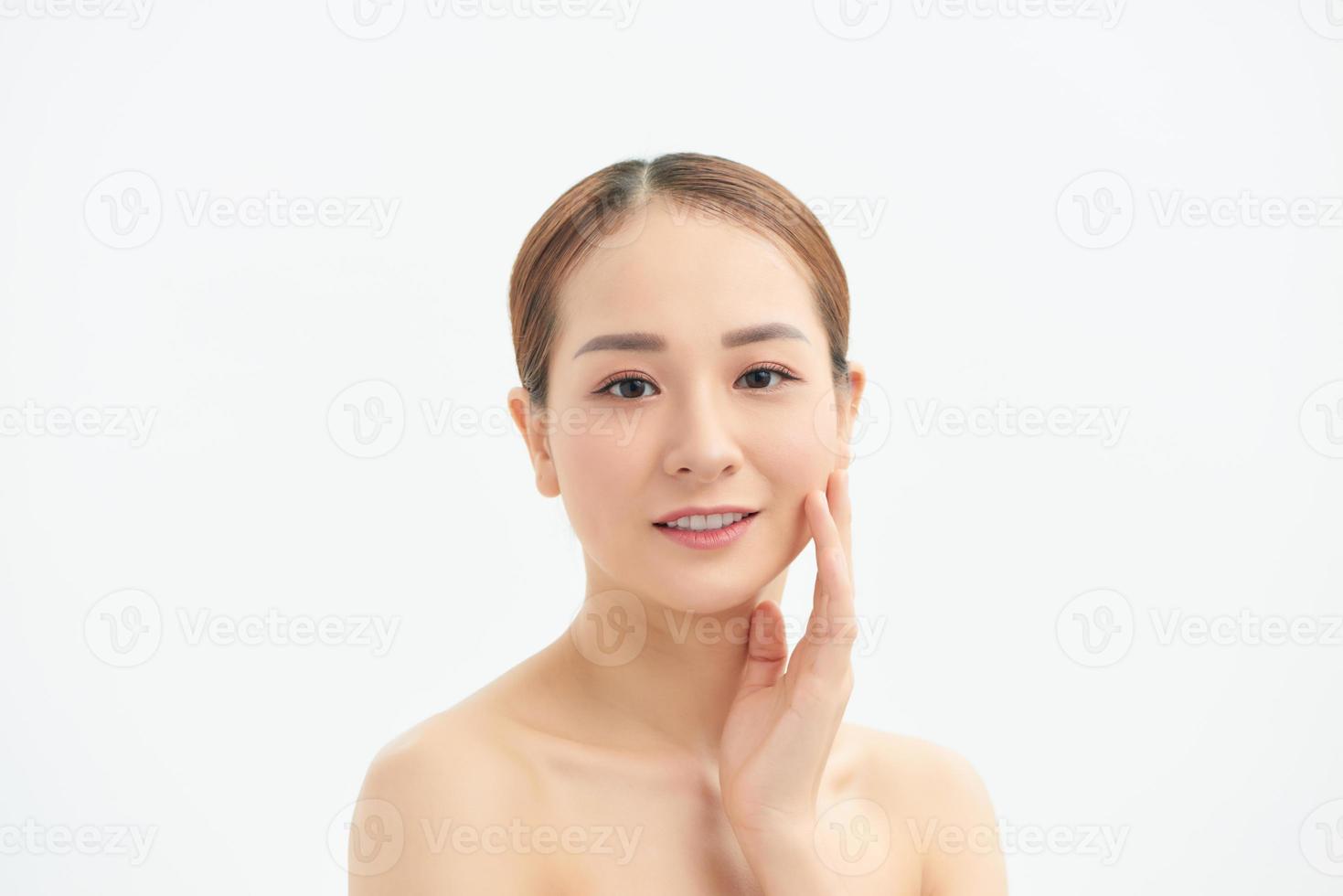 A sweet Asian girl with a clean perfect face closed her eyes with tenderness touching the skin photo