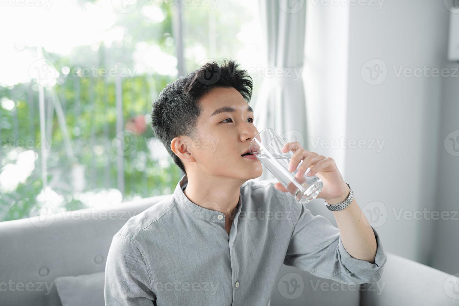 hombre guapo bebiendo un vaso de agua fresca foto