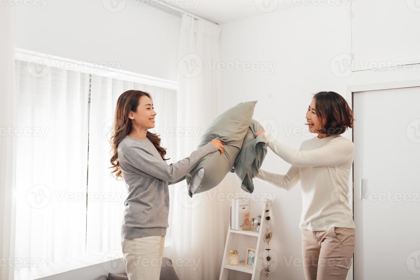 hermosas dos chicas sexy divirtiéndose en el dormitorio, pelea de almohadas. foto